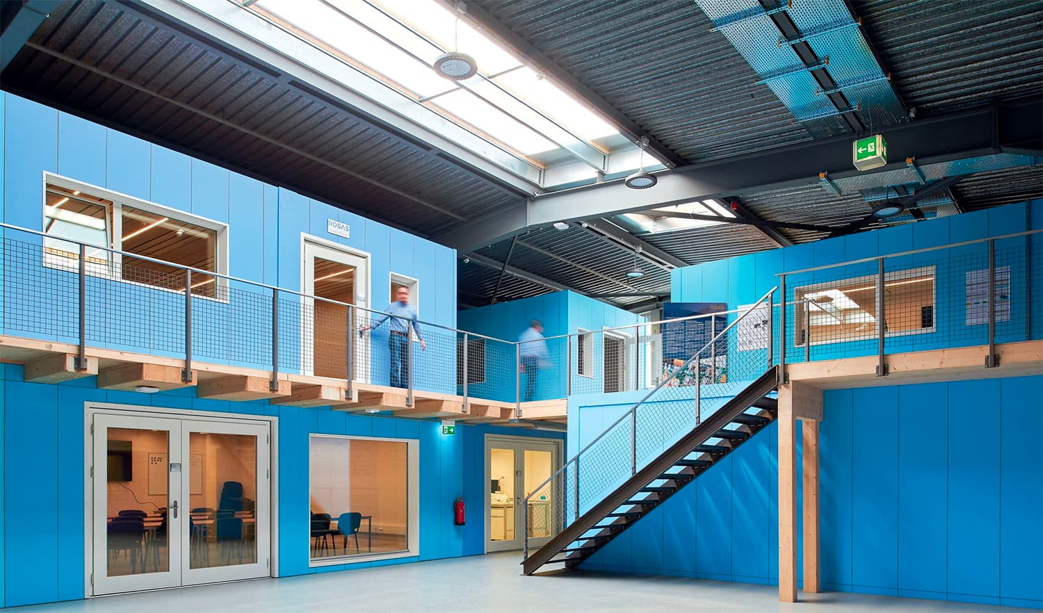 Des modules en bois dans un entrepôt par l'atelier d'architecture Lutz Associés à Fribourg
